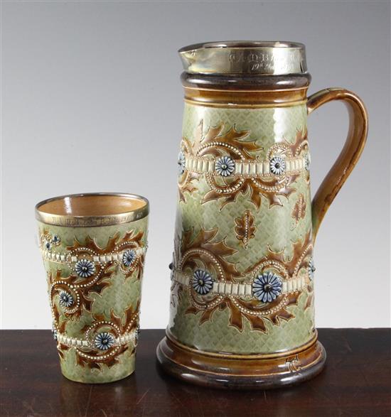 George Tinworth for Doulton Lambeth. A stoneware jug and matching beaker, 24.5cm (9.6in.) & 13cm (5.1in.)